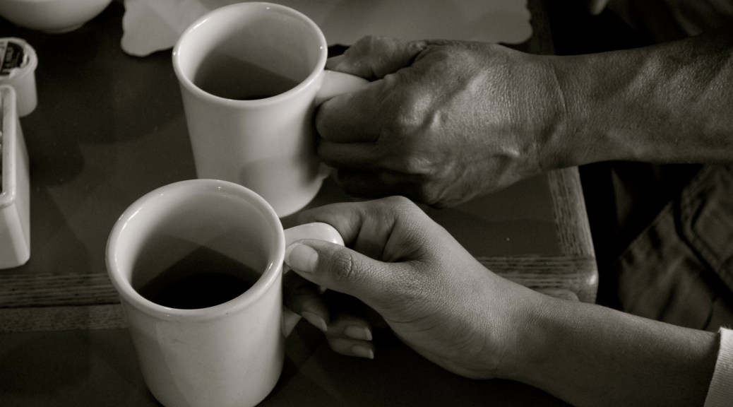 two hands each holding a coffee cup